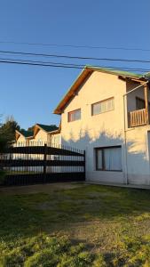 a white house with a fence in a yard at Hotel Hielo Azul 1 in El Bolsón