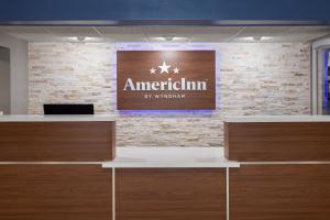 a lobby with a sign on a brick wall at AmericInn by Wyndham Appleton North Little Chute in Appleton +62 photos