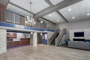 a lobby of a hospital with a staircase and a couch at AmericInn by Wyndham Appleton North Little Chute in Appleton