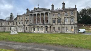 a large building with a van parked in front of it at Plas Glynllifon Mansion in Caernarfon