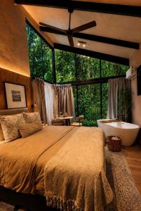 a bedroom with a large bed and a bath tub at KAÑIK APART HOTEL in Puerto Viejo