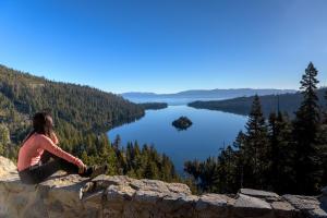 a woman sitting on a rock overlooking a lake at Tahoe Keys #214 in South Lake Tahoe