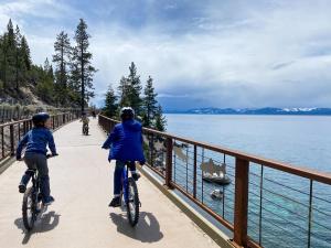 two people riding bikes on a bridge by the water at Tahoe Keys #214 in South Lake Tahoe +33 photos