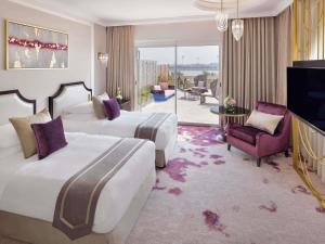 a hotel room with two beds and a balcony at Mövenpick Hotel Bahrain in Manama