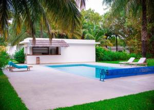 a swimming pool with two chairs and a house at Cap DIOLA in Cap Skirring