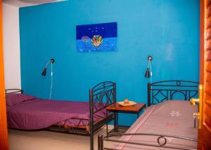 a room with two beds and a blue wall at Cap DIOLA in Cap Skirring +17 photos
