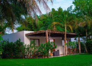 a house with palm trees and a green lawn at Cap DIOLA in Cap Skirring