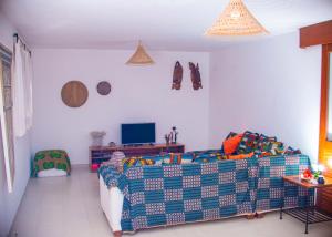 a living room with a couch and a tv at Cap DIOLA in Cap Skirring