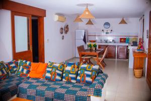 a living room with a couch and a kitchen at Cap DIOLA in Cap Skirring