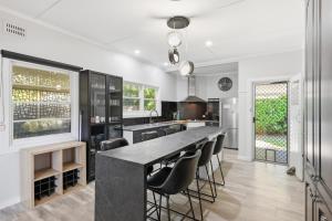 a kitchen with a large black table and chairs at 2 Long between breaks in Coffs Harbour