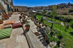 an outdoor patio with pillows and plants in a yard at Goreme Inn Hotel Only Adult in Göreme +115 photos