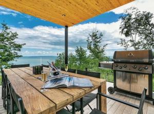a wooden table on a deck with a grill at Secret Charlevoix - River View & Spa in Les Éboulements