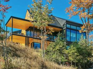 a house on top of a hill with trees at Secret Charlevoix - River View & Spa in Les Éboulements