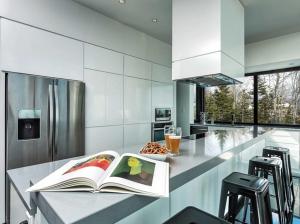 a kitchen with an open book on a counter at Secret Charlevoix - River View & Spa in Les Éboulements