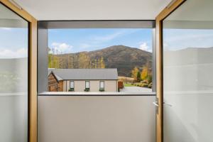 a window with a view of a house at Gibbston Hideaway in Gibbston