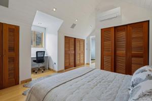 a bedroom with a bed with wooden doors and a desk at Gibbston Hideaway in Gibbston