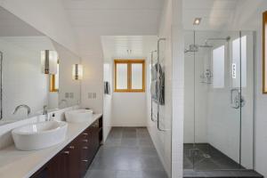 a bathroom with two sinks and a shower at Gibbston Hideaway in Gibbston +11 photos