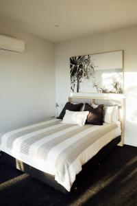a bedroom with a large bed with a large painting on the wall at Kais Retreat in Punakaiki