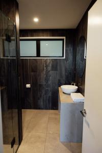 a bathroom with a sink and a glass shower at Kais Retreat in Punakaiki +32 photos