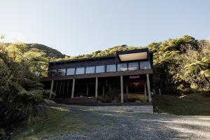a house on a hill with a road in front of it at Kais Retreat in Punakaiki