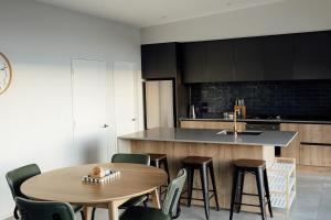 a kitchen with a table and chairs and a sink at Kais Retreat in Punakaiki