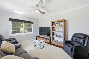 a living room with two couches and a tv at 2 Long between breaks in Coffs Harbour