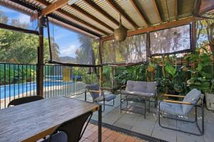 a patio with a table and chairs and a pool at 2 Long between breaks in Coffs Harbour