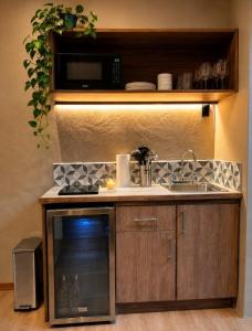 a kitchen with a sink and a microwave at KAÑIK APART HOTEL in Puerto Viejo