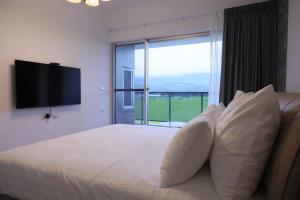 a bedroom with a large bed with a large window at Go Chishang B&B in Chishang