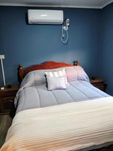 a bedroom with a bed with a air conditioner on the wall at Kaike in Caleta Olivia