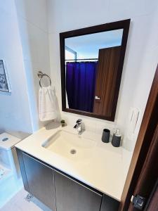 a white bathroom with a sink and a mirror at Cozy Apartment 4 degrees north in Las Victorias +19 photos