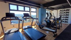 a gym with several tread machines and a window at Cozy Apartment 4 degrees north in Las Victorias