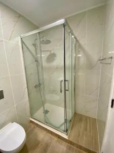 a glass shower in a bathroom with a toilet at Sea View urban apartment in Faro