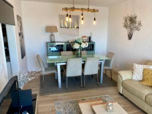 a dining room and living room with a table and chairs at Sea View urban apartment in Faro +17 photos