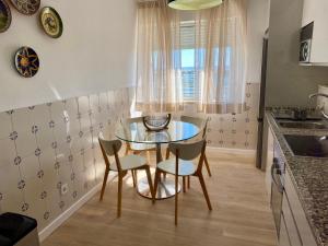 a small kitchen with a glass table and chairs at Sea View urban apartment in Faro