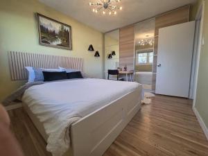 a bedroom with a large white bed and a bathroom at Room with Shared Bathroom - Stampede & Mountains in Calgary