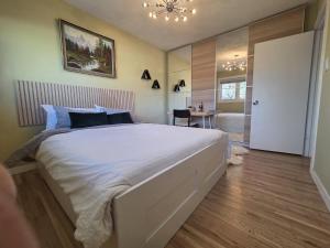 a bedroom with a large white bed and a bathroom at Room with Shared Bathroom - Stampede & Mountains in Calgary
