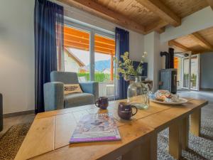 a living room with a wooden table and a couch at Villa Alpenrose in Kötschach