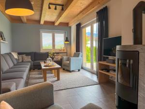 a living room with a couch and a tv at Villa Alpenrose in Kötschach