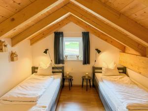two beds in a room with a roof at Villa Alpenrose in Kötschach