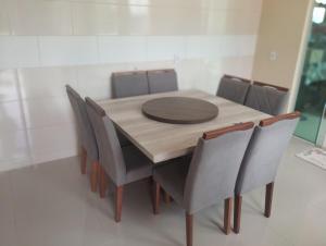 a dining room table with chairs and a wooden table at Chacara Urbana in Navegantes