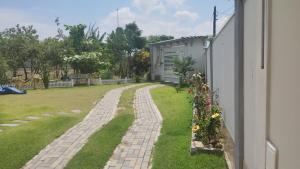 a garden with a brick walkway next to a building at Chacara Urbana in Navegantes