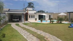 a house with a driveway and a yard at Chacara Urbana in Navegantes