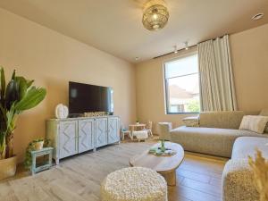 a living room with a couch and a tv at t Margrietje in Riemst