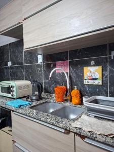 a kitchen counter with a sink and a microwave at Noche Hermosa in Chilecito +8 photos