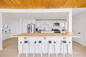 a kitchen with white cabinets and a wooden ceiling at 2Homes Villa Renovated Views in La Mesa