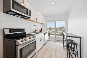a kitchen with a stove and a sink and a counter at 2Homes Villa Renovated Views in La Mesa