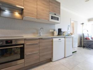 a kitchen with wooden cabinets and a sink and a dishwasher at 2000 - 0302 + park. 3 in Middelkerke