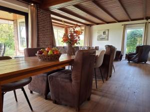 a dining room with a wooden table and chairs at Genderens Buiten in Genderen