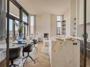 a kitchen and living room with a table and chairs at Zilte Watervilla in Kamperland